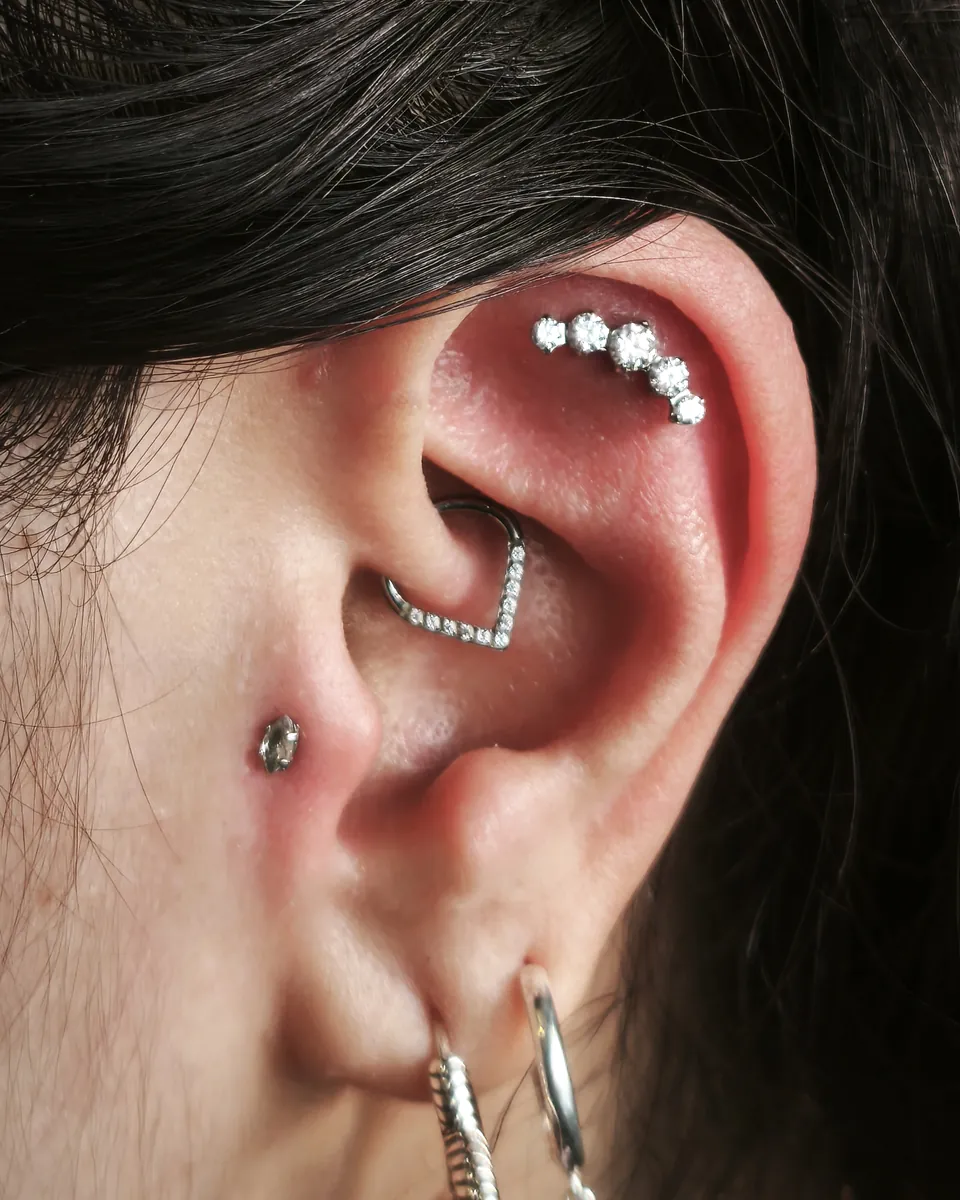 Oreja con barra de brillantes en el helix, joya en el conch y aros en el lóbulo