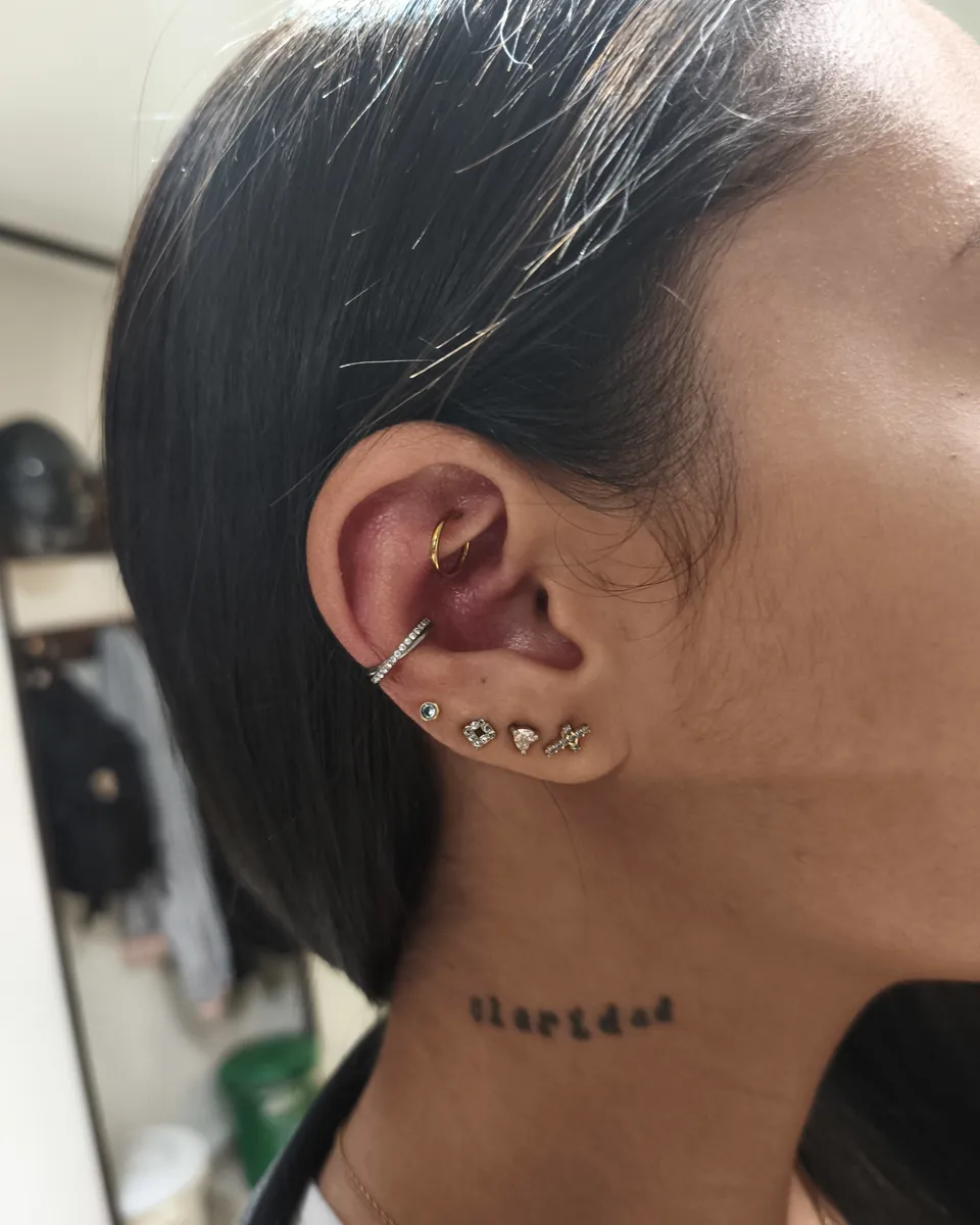 Oreja con perforaciones en el lóbulo y en el cartílago, recién hechas en el estudio