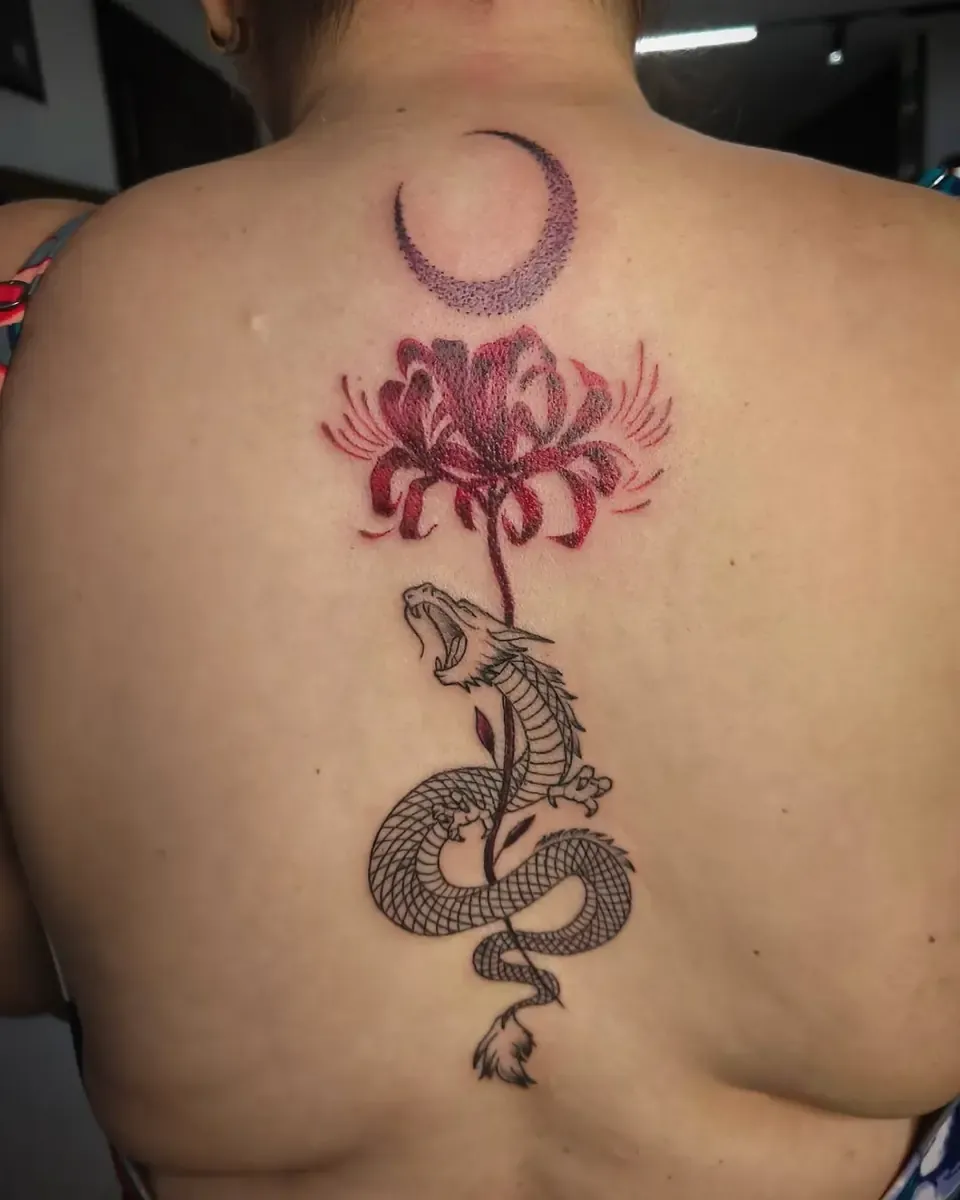 Tatuaje fine line en la espalda con una luna, un lirio rojo y una serpiente